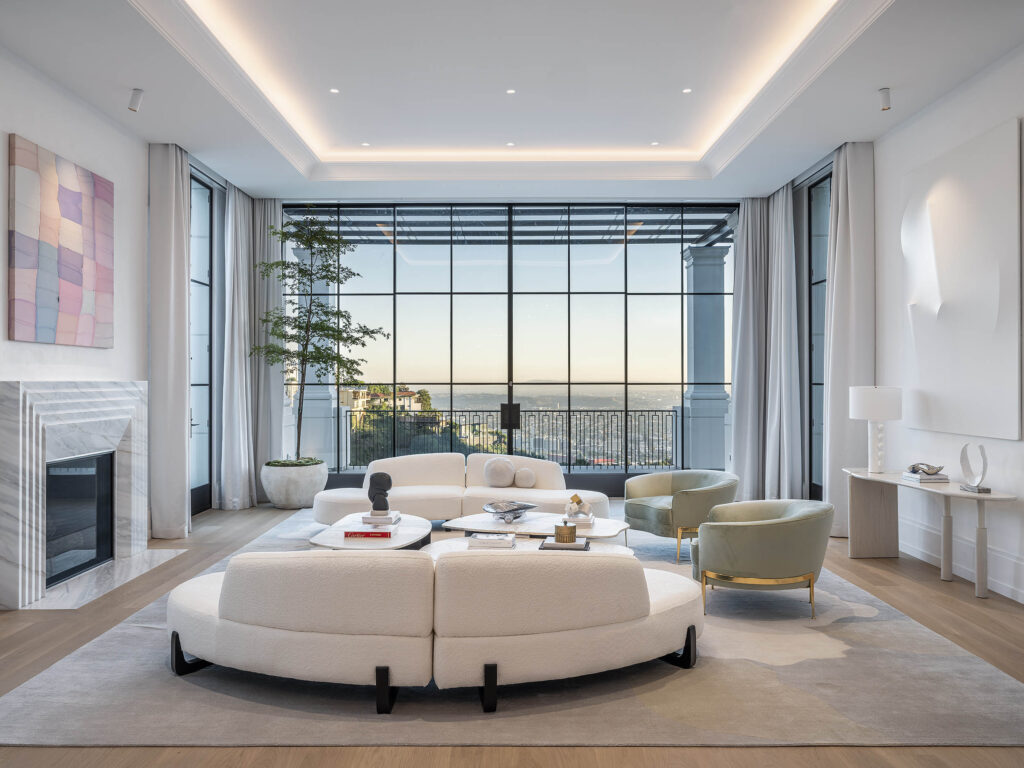 A spacious and elegantly designed living room from the Birds Street project by Coppel Design, featuring modern furnishings, artistic decor, and large windows that bring in abundant natural light.