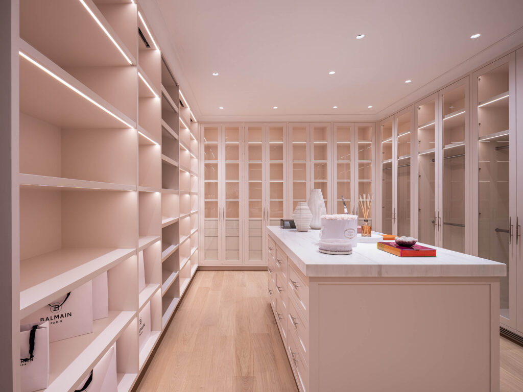 A luxurious walk-in closet designed by Coppel Design for the Birds Street project, featuring custom shelving, elegant lighting, and ample space for clothing and accessories.