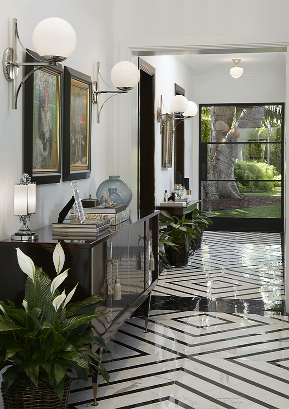 A grand entrance hall designed by Coppel Design for the Hombly Hills project, featuring a minimalist design with a sculptural console table, large mirror, sleek lighting, and neutral tones that create an inviting, luxurious ambiance.