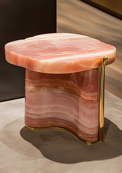 A pair of bespoke side tables, Petra I and II by Coppel Design, featuring organic, rock-like forms with smooth, sculptural surfaces made from solid stone, showcasing natural textures and hues.